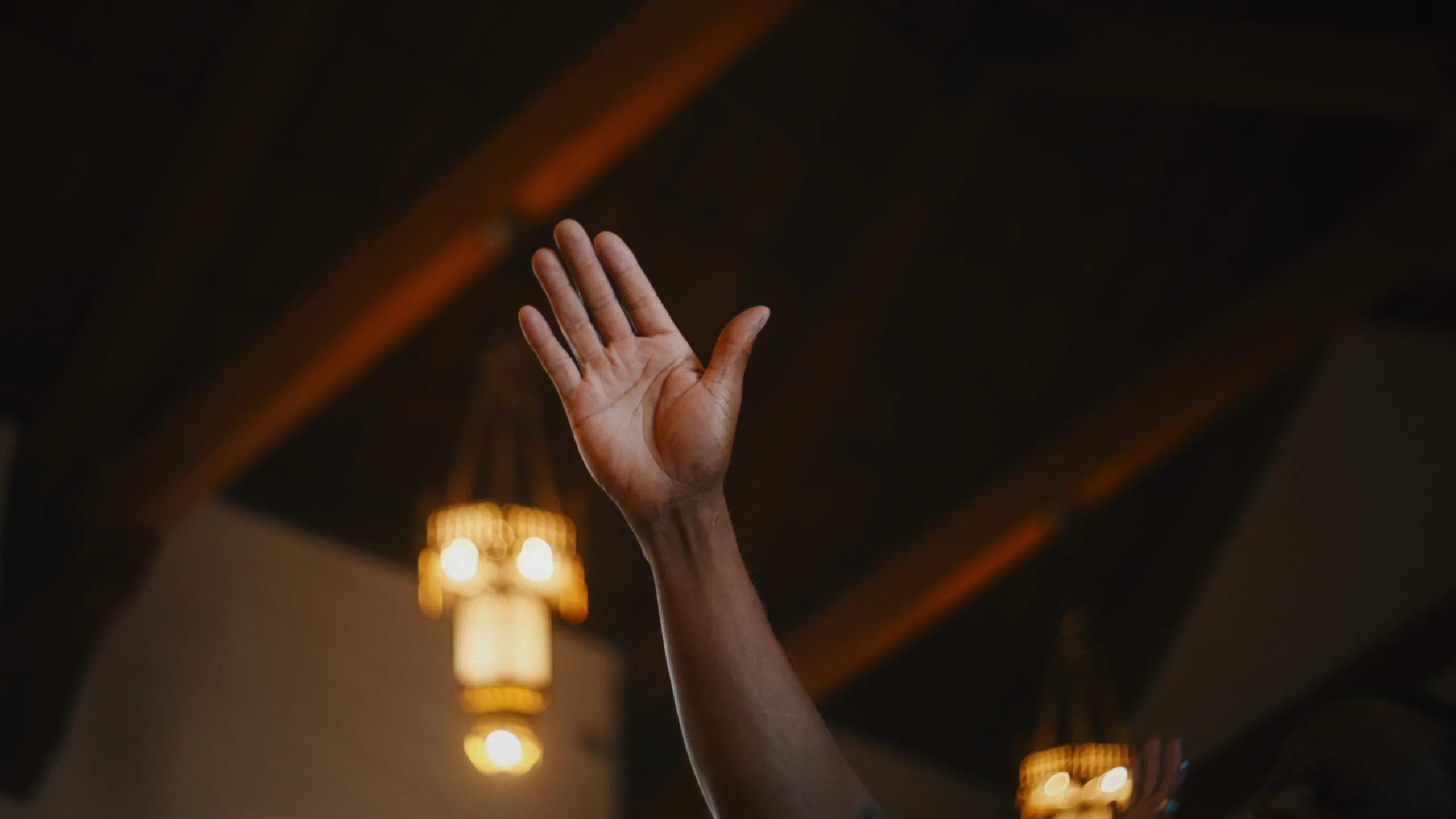 Raised hand in a sanctuary frame, before and after a Blueprint PowerGrade — graded