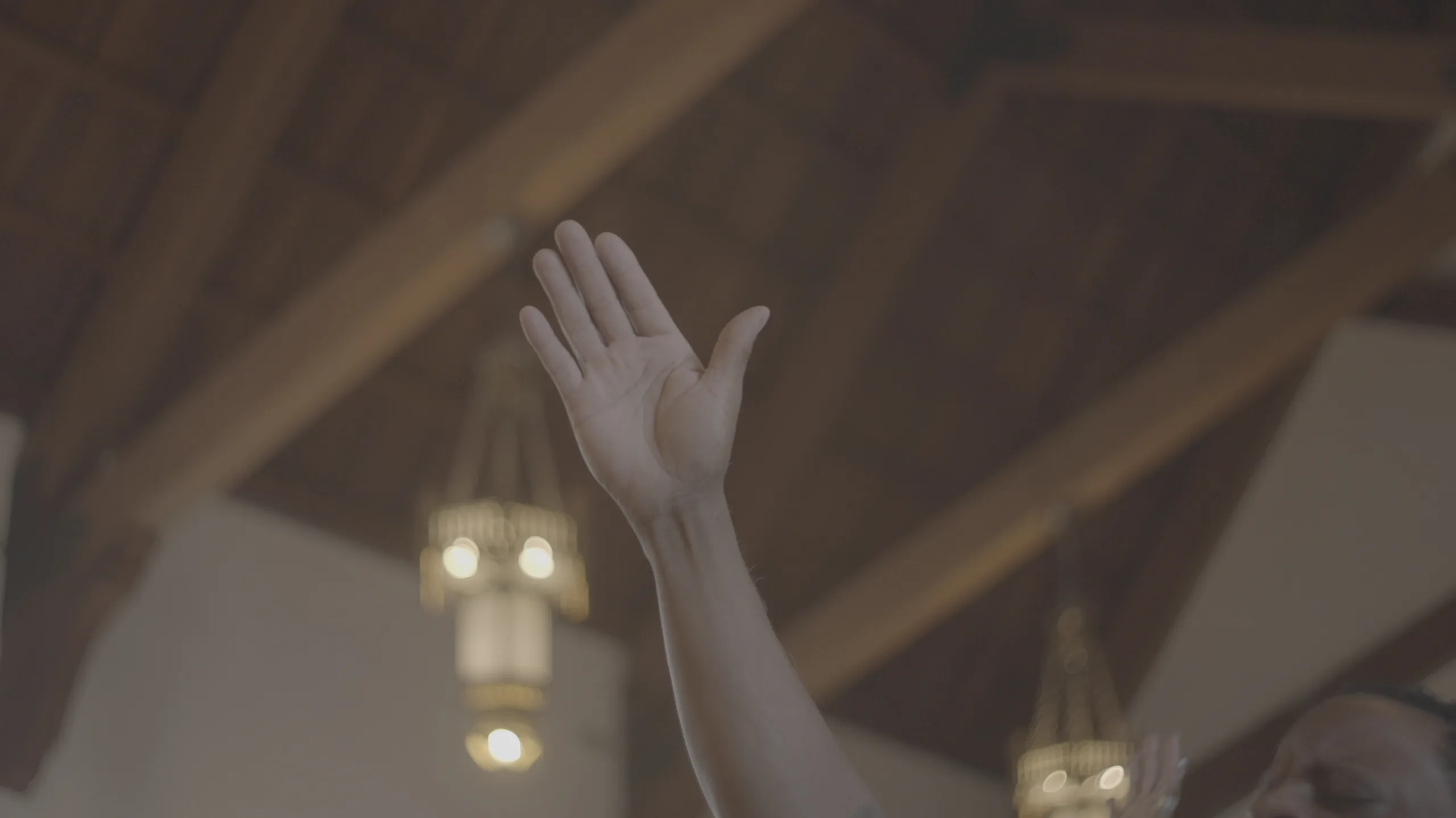 Raised hand in a sanctuary frame, before and after a Blueprint PowerGrade — before grading